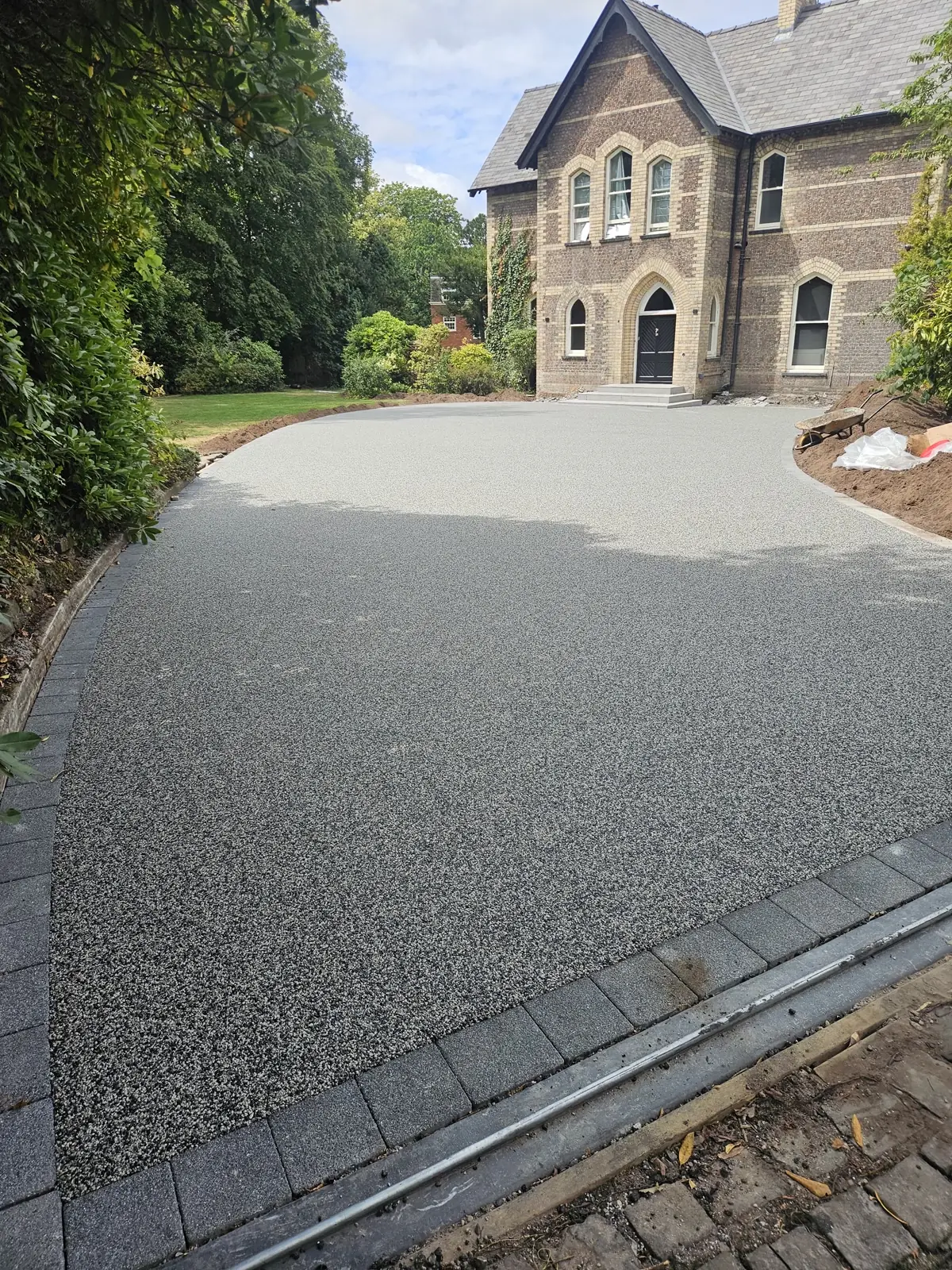 Large-scale Moonshadow resin bound surfacing, permeable and hand-trowelled, across a 250 square metre forecourt in Altrincham