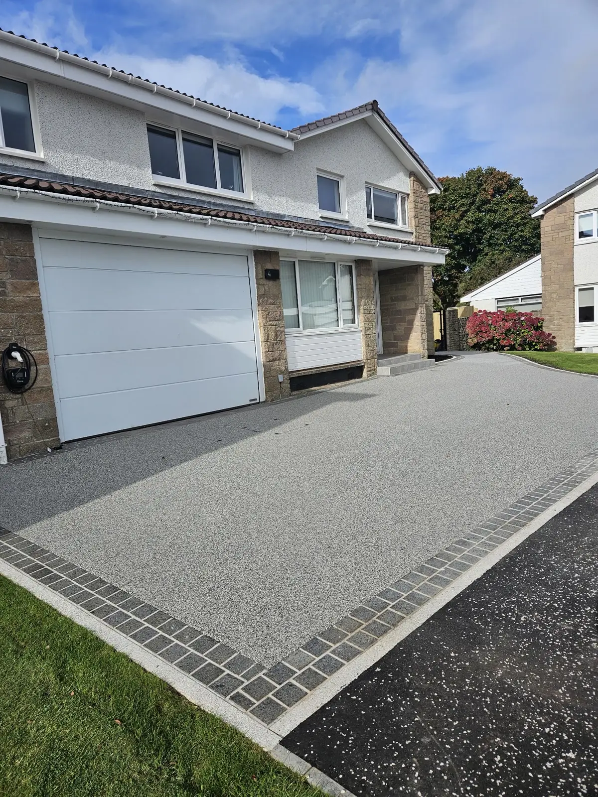 Titan Silver resin bound driveway with a block-paving sett border, permeable and hand-trowelled, at a house in Paisley